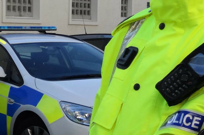 Police Scotland officer in front of police car 